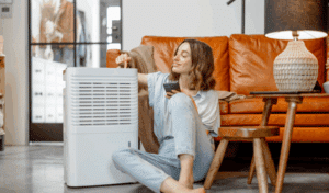 A person sitting on the floor next to their air purifier unit