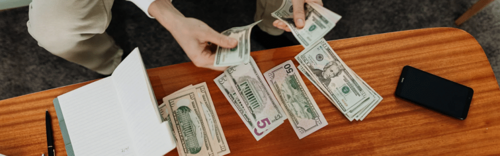 Man counting money on a table.