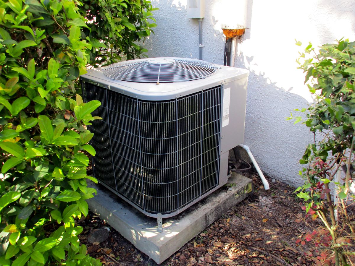 Air Conditioning Unit On Side of Florida House with Green Bushes