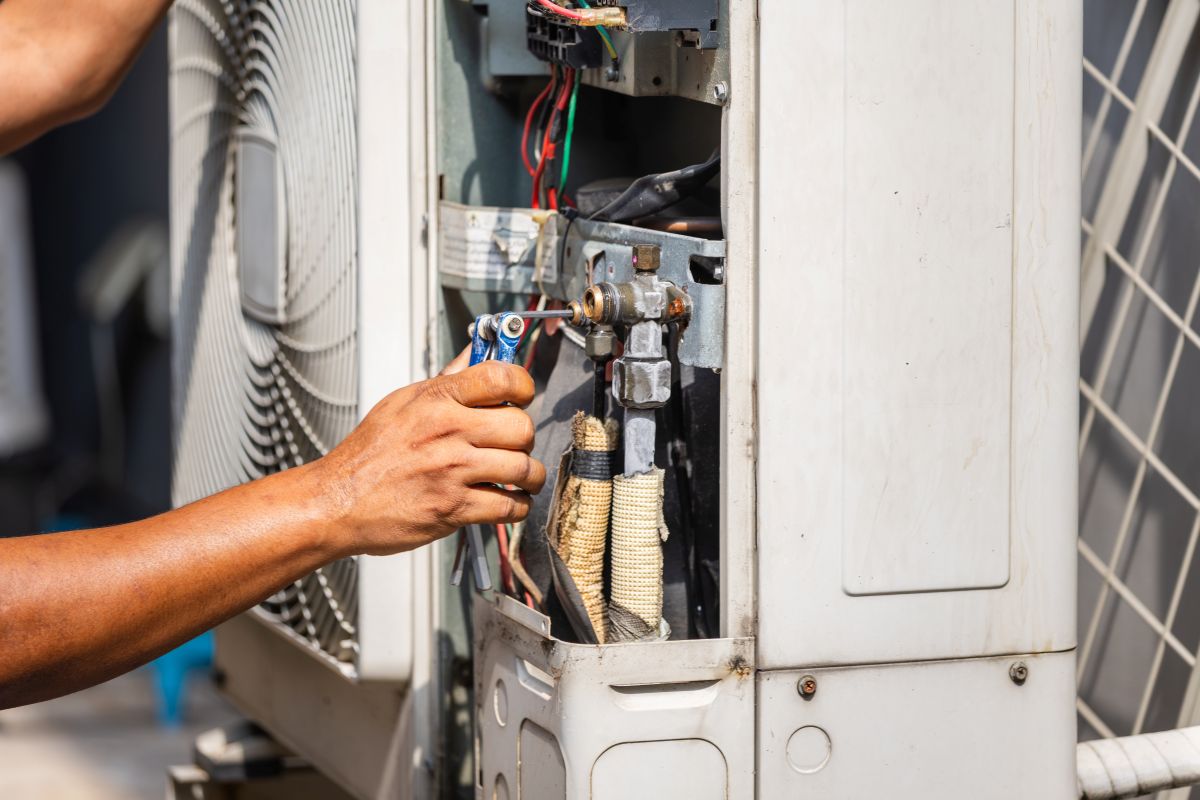 Technician performing maintenance service on home air conditioning system