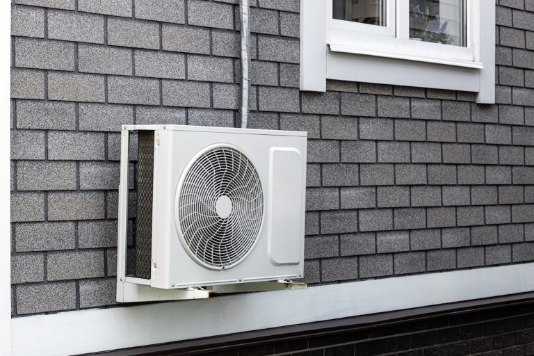the external unit of the air conditioner is attached to the wall of the house. outdoor air conditioner unit. air conditioning system of a residential building.