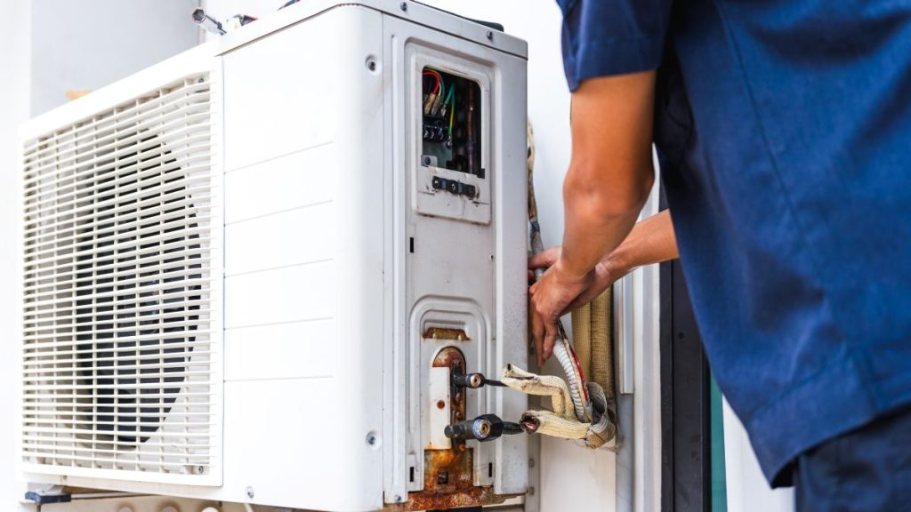 HVAC Technician Fixing an Outdoor Air Conditioning Unit