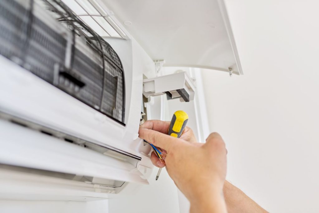 Installing-an-air-conditioner-in-an-apartment-office-close-up-of-an-engineer-hand